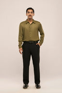 Man in dark olive lyocell shirt with glossy finish, full sleeves, button loop detailing, paired with black pants and shoes.