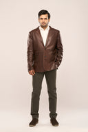 Man wearing coffee brown genuine leather blazer featuring notch collar, patch pockets, and horn buttons, with brown pants