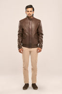Man wearing coffee brown lamb nappa leather jacket, snap-button collar, quilt detail, flap pockets, paired with beige pants.