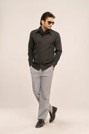 Model in charcoal black pleat shirt showcasing front pleats and modern slim-fit silhouette, worn with grey trousers.