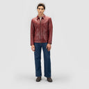 Man wearing rust red leather jacket for men in regular fit, featuring full sleeves, zipper closures, paired with blue jeans