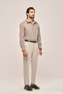 Side view of man in gray pleat shirt showing slim fit, full sleeves and structured design, paired with light trousers.
