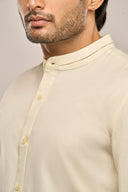 Close-up of yellow shirt for men featuring mandarin collar and button-down front.
