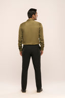 Man's back view in a slim-fit dark olive lyocell shirt with glossy finish and full sleeves, paired with black pants.