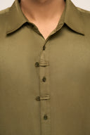 Close up of a man wearing a lyocell shirt in dark olive featuring unique button loop detail, front view.