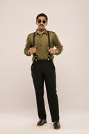 A man in a slim-fit dark olive lyocell shirt featuring full sleeves and button loops, paired with black pants & suspenders.