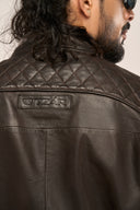 Close-up back view of man wearing black lamb nappa leather jacket, TZÁR branding and quilted detail.