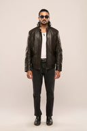 Man wearing black soft leather jacket, front zipper, full sleeves, flap pockets, quilt detail, regular fit, with black jeans.