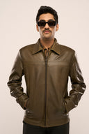 Man wearing dark olive leather jacket for men, front zip closure, structured collar, zipper pockets, styled with sunglasses