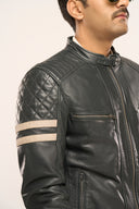 Close-up of man wearing navy blue leather Biker Jacket with quilted shoulder pads, front zipper and multiple zipper pockets 