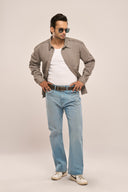 A man poses in jeans and sunglasses, wearing a grey men's shirt jacket with full sleeves, snap buttons, and a front pocket.