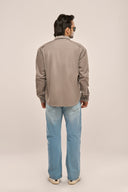 Back view of a man in a grey shirt jacket, relaxed fit, drop shoulders, paired with jeans.