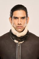 Close-up of man wearing distressed coffee brown leather jacket for men featuring fur collar, zipper front, buckle closures.