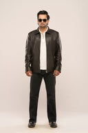 Man wearing black leather jacket, structured fit, front zip closure, slip-in pockets, paired with black jeans and white shirt