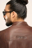 Back of the coffee brown genuine leather Biker Jacket with TZÁR logo worn by man wearing sunglasses 