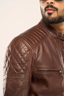 Close-up of man wearing coffee brown leather biker jacket with focus on zipper pockets, front zipper and snap buttons