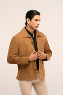 Man wearing regular fit brown suede leather jacket close-up side view showing flap pockets, full sleeves, and horn buttons.