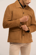 Side view close-up of man in brown suede leather jacket featuring collar, full sleeves, flap pockets, and horn buttons.