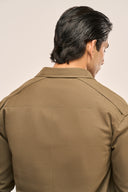 Back view of a man wearing a relaxed-fit olive color men's shacket with dropped shoulders.