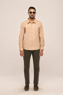 Man wearing beige slim fit shirt for men with button-down front, full sleeves and neat silhouette, styled dark brown pants.