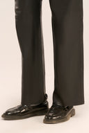 Close up of straight-fit genuine goat Nappa leather black pants for men paired with a pair of black shoes