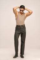 Man posing while wearing beige vest with a pair of men’s black leather trousers with two front slip-in and two back pockets