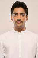 Close-up of man wearing white shirt for men in relaxed fit, featuring mandarin collar and button-down front.